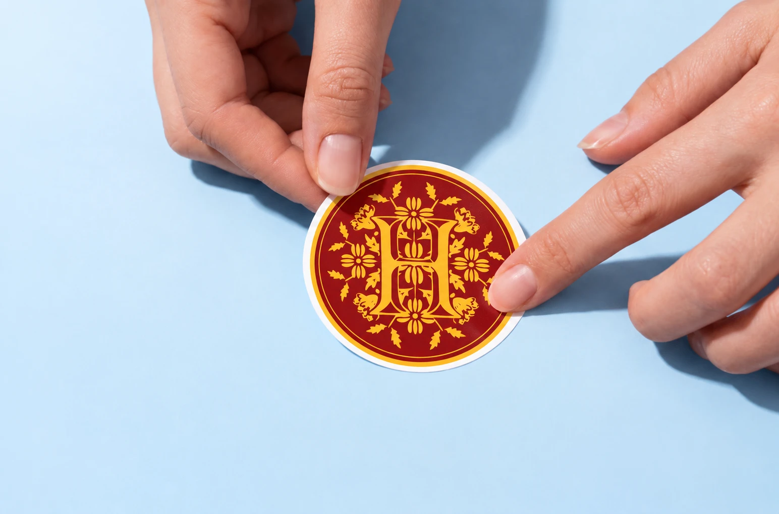 Hands applying a round crest sticker