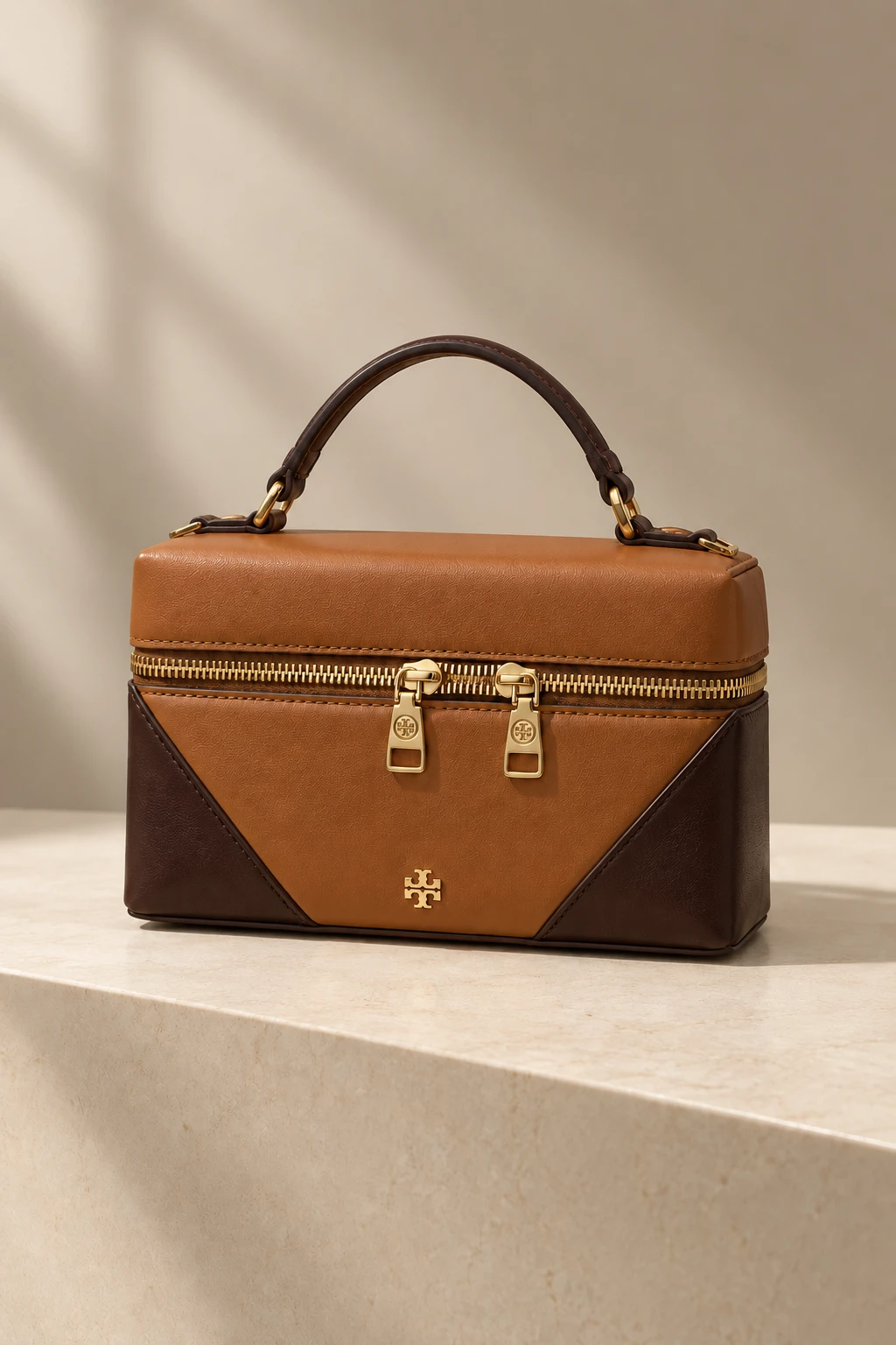 Saddler: cognac leather vanity case with chocolate corner panels and gold hardware